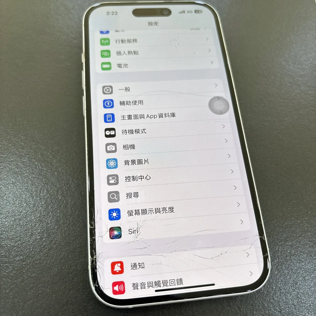 台南 iPhone 15 螢幕外玻璃碎裂,下半部整片蜘蛛網裂痕但顯示正常