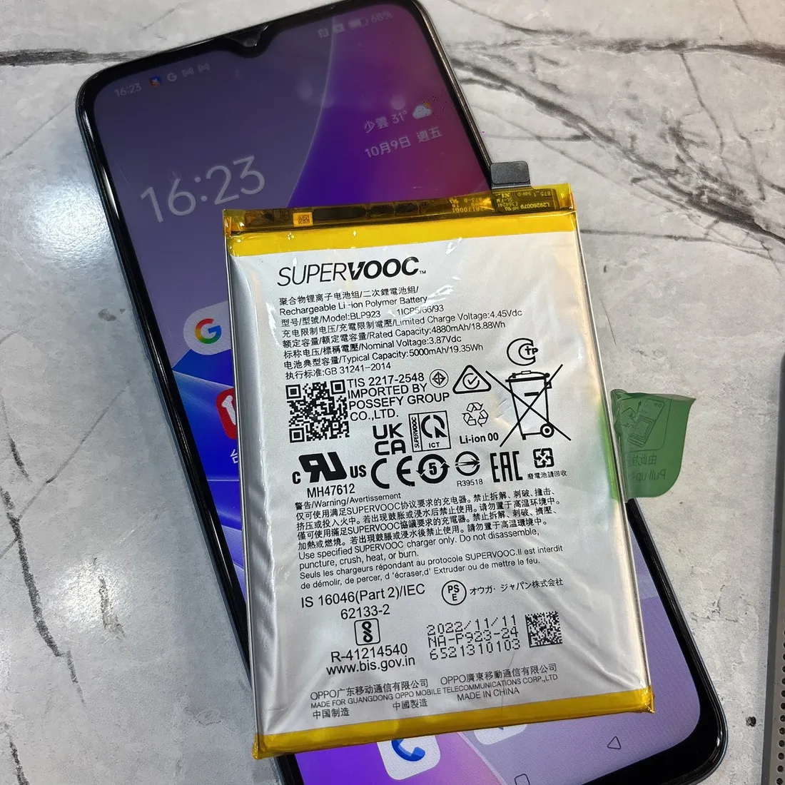 台南 OPPO A77 5G 換電池完成開機正常,上方為換下的膨脹電池 BLP923